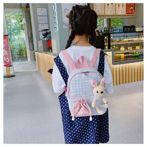 Detail of cute plush bunny on blue plaid kids backpack with pink drawstring pocket