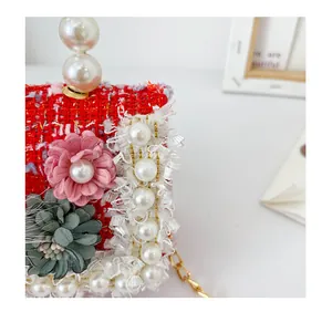 Gros plan du sac en tweed rouge avec fleurs 3D, bordure dentelle et anse perles