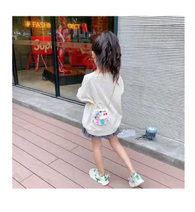 Detail of girls mini pearl handbag with floral 3D decor and cartoon rabbit on the strap