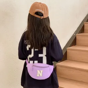 Kids purple canvas waist bag with letter N embroidery shown on model from behind