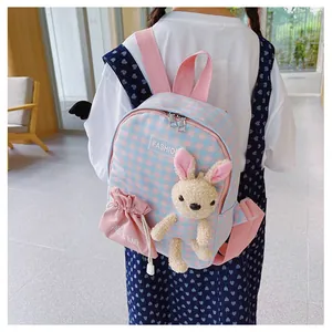 Detail of pink and blue plaid children backpack with cute plush rabbit and side drawstring pouch