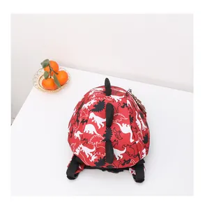Detail of red toddler dinosaur backpack with 3D black spikes and adjustable straps