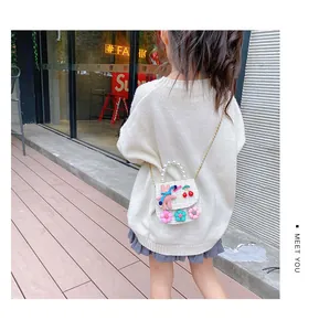 Detail of tweed girl's crossbody bag with pearl handle and plush bunny decoration