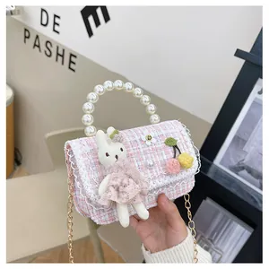 Détail du sac fille en tweed rose avec poignée en perles et pendentif lapin