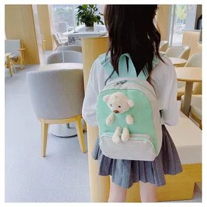 Detail of mint green plaid kids backpack featuring a 3D plush bear on back for girls