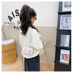Détail du sac à carreaux rose pour enfant avec poignée en perles et charm de lapin