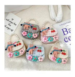 Flat lay of tweed girls handbags with pearl handles and cute bear charms in multiple colors