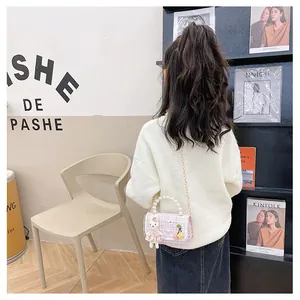 Détail du sac fille en tweed rose avec lapin en peluche, perles et bandoulière dorée