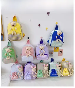 Detail of colorful kids backpacks with cute plush bunny decor and plaid canvas design