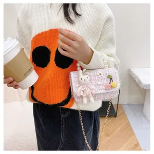 Détail du sac en tweed rose pour fille avec anse en perles et ornement lapin mignon