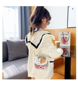 Detail of girls' tweed crossbody bag with 3D bunny patch and pearl top handle decoration