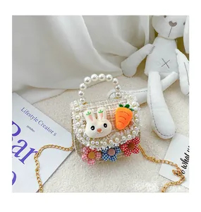 Detail of tweed kids handbag with plush bunny, carrot decor and pearl handle strap