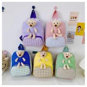 Close-up of cute cartoon toddler backpacks in five pastel colors with plush bear charms