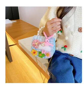 Blue tweed bag detail with floral accents, pearl handle, and cute plush rabbit charm