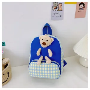 Detail of blue and yellow plaid kids backpack with a 3D plush bear and canvas texture