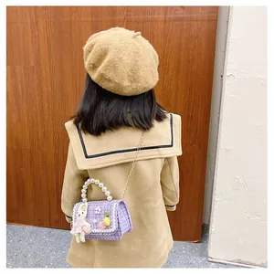 Fille portant un sac à main en tweed violet avec anse perle et lapin en peluche