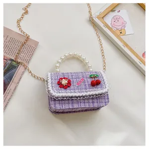 Detail of purple tweed girls handbag with lace trim and large pearl handle strap