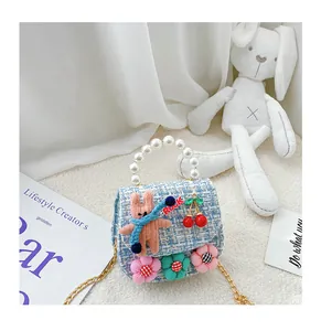Detail of tweed girl's mini bag with plush bunny, pearls, and gold chain strap