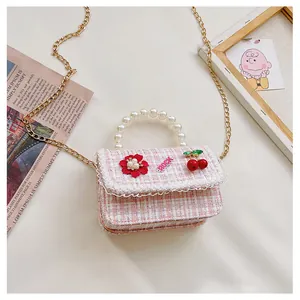 Detail of pink tweed kids crossbody bag with pearl handle and lace trim accents