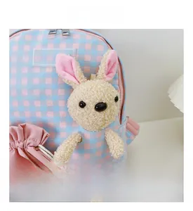Detail shot of the blue and pink plaid kids backpack featuring a cute plush bunny doll