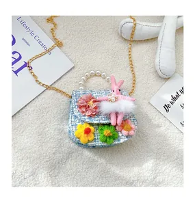 Detail of blue tweed kids bag with handmade crochet flowers, pearls, and a 3D bunny toy