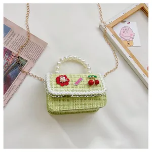 Detail of green tweed children's bag with pearl handle, red flowers and lace trim