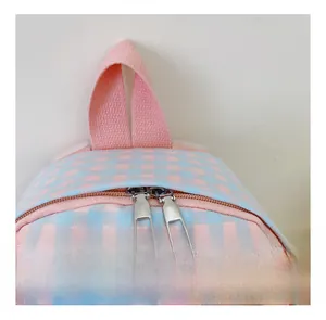 Detail of pink and blue plaid kids backpack showing smooth zipper and webbing handle