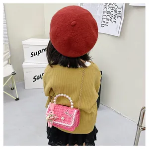 Détail du sac enfant en tweed rose avec poignée en perles et pendentif lapin