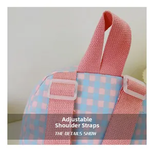 Detail of adjustable shoulder straps and plastic buckles on pink plaid kids backpack