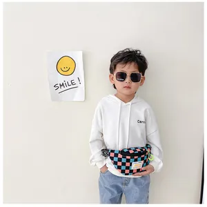 Close-up of kids checkered chest bag with pink and cyan squares and yellow zipper detail
