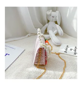 Detail of tweed girls crossbody bag with pearl handle and cute rabbit charm