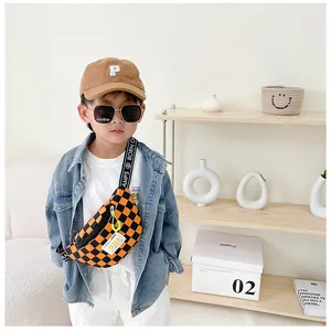 Detail of orange checkered kids chest bag with green zipper and branded strap