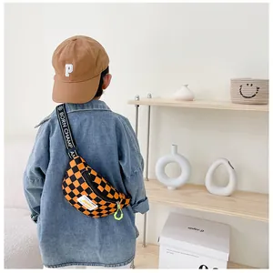 Detail view of boys checkerboard chest bag with Born Champ letter strap and green zipper
