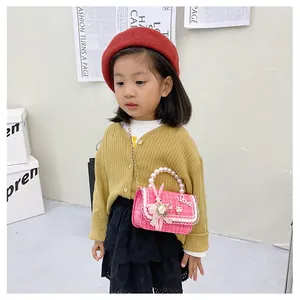 Détail du sac fille en tweed rose avec poignée en perle, lapin et dentelle