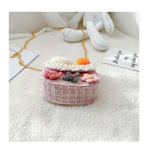Close-up of pink tweed kids crossbody bag with floral accents and gold chain strap