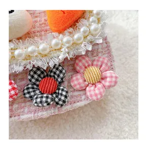 Detail of pink tweed texture with pearls, lace, and small checkered fabric flowers