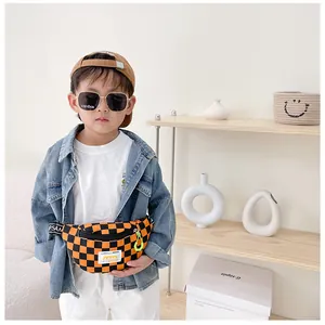Detail of checkered canvas kids chest bag with orange and black pattern and logo