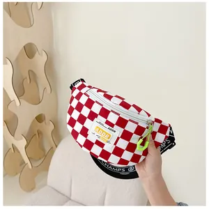Detail of red and white checkered kids chest bag with ADDR label and neon green hook