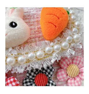 Detail of pink tweed bag featuring plush rabbit, carrot and pearl border accents
