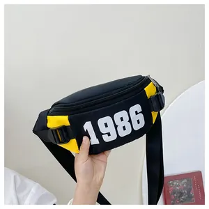 Detail of kids chest bag with 1986 logo, adjustable buckle and yellow contrast zip