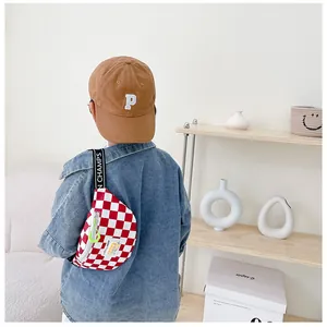Macro detail of kids red checkered chest bag with branded strap and neon zipper pull