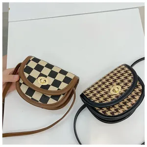 Detail of vintage girls' checkered saddle bags with metallic twist locks and leather straps