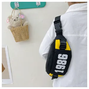 Detail of a black and yellow crossbody chest bag with 1986 print and adjustable strap