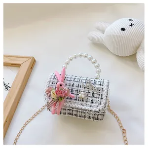 Détail du mini sac en tweed avec poignée perle, dentelle et déco lapin mignon