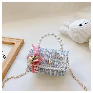 Détail du sac enfant en tweed avec poignée en perles et pendentif lapin en peluche