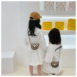Detail of checkered and houndstooth mini saddle bags with gold buckles for girls