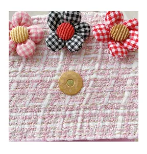 Detail of pink tweed girl purse with three floral ornaments and golden magnetic clasp