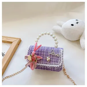 Détail d'un sac en tweed violet pour enfants avec poignée en perles et lapin mignon