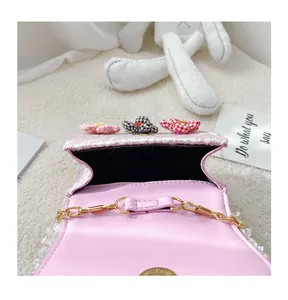 Detail view of pink woven bag featuring magnetic clasp, interior lining and floral accents