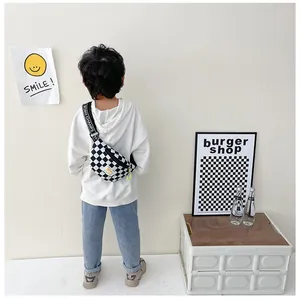 Close-up of kids checkerboard chest bag with adjustable lettered strap and yellow logo